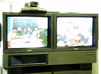 Left television: Fermilab; right television: Michigan