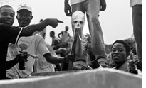 Men brandish a human skull during Decoration Day in Monrovia 
Click image to expand.