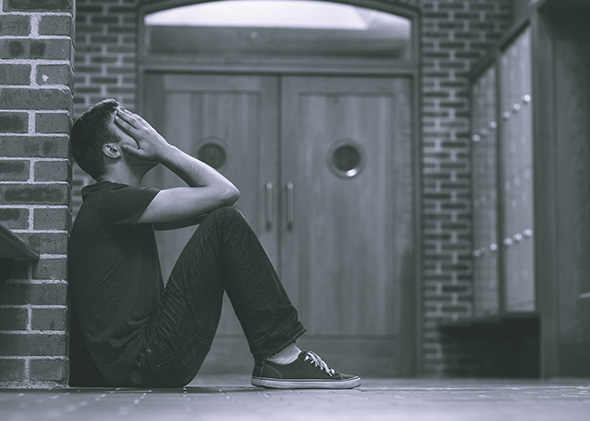 Stressed out student in hallway of school building.