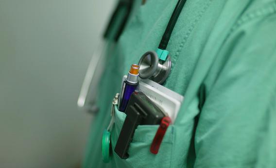 A doctor wearing green scrubs and a stethoscope.