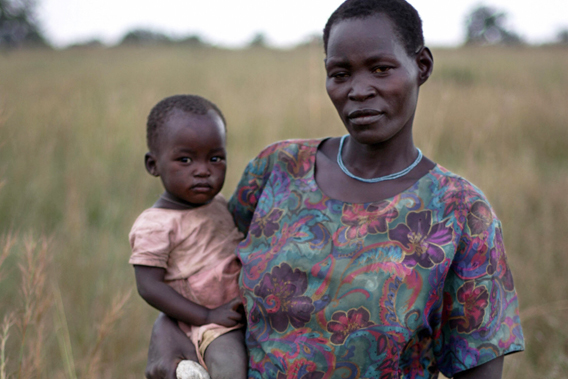 An Ugandan woman holds her child as she holds a small bag containing kernels of beans that were strewn in the brush as bags of food relief ruptured on impact after they were air dropped by a World Food Program (WFP) aircraft in the Olilim camp for Internally displace people in the Lira District of northern Uganda, 19 October 2007. An UAn Ugandan woman holds her child and a small bag containing kernels of beans that were strewn in the brush as bags of food relief ruptured on impact after they were air dropped by a WFP aircraft in northern Uganda on Oct. 19, 2007gandan woman holds her child as she holds a small bag containing kernels of beans that were strewn in the brush as bags of food relief ruptured on impact after they were air dropped by a World Food Program (WFP) aircraft in the Olilim camp for Internally displace people in the Lira District of northern Uganda, 19 October 2007.