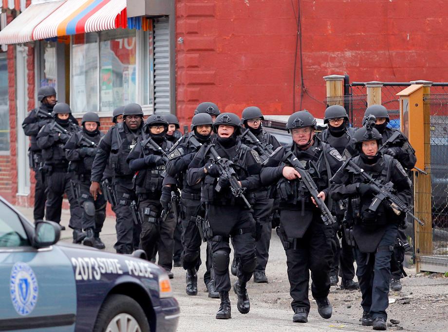 SWAT teams enter a suburban neighborhood to search an apartment for the remaining suspect in the Boston Marathon bombings in Watertown, Massachusetts April 19, 2013. Police killed one suspect in the Boston Marathon bombing during a shootout and were engaged in a house-to-house search for a second man on Friday in the Boston suburb of Watertown after a bloody night of shooting and explosions in the city's streets.