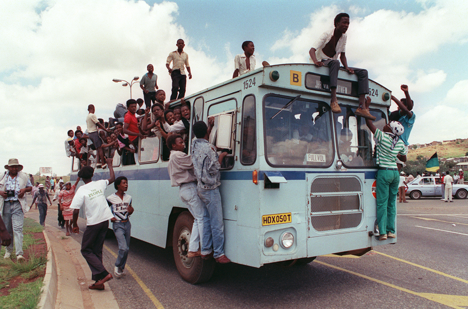 Jubilant inhabitants of Soweto find room where they can in and on a bus to reach Orlando stadium in Soweto, 12 February 1990, to attend a mass African National Congress (ANC) rally to be addressed by freed anti-apartheid leader and African National Congress (ANC) member Nelson Mandela. It's the first rally Nelson Mandela is holding since his release from jail, 11 February 1990. 