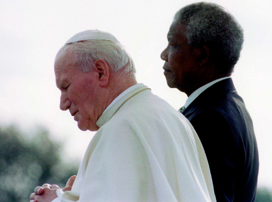 South African President Nelson Mandela (R) and Pope John Paul II listen to national anthems after they met at Johannesburg International Airport September 16, 1995, at the start of the pope's first official visit to the country. 