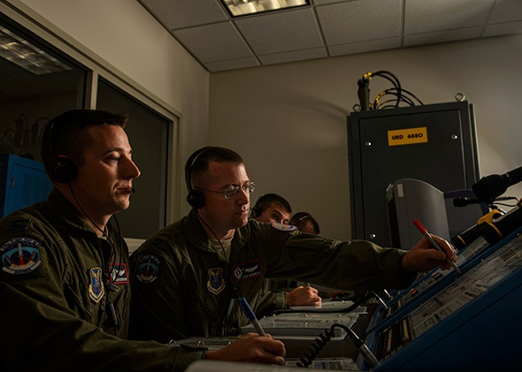 U.S. Air Force Capt. Daniel Moore, front, and Capt. Kyle Heiderich, back, check a launch control center.