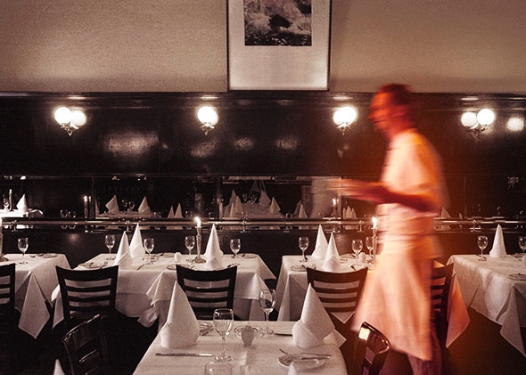 Waiter walking through restaurant, blurred motion.