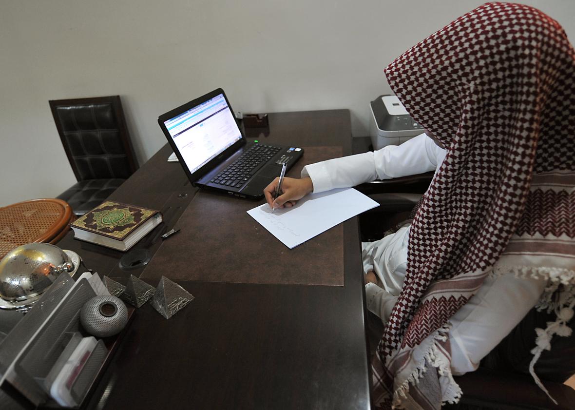 183435496-saudi-man-writes-notes-in-front-of-his-laptop-on-his