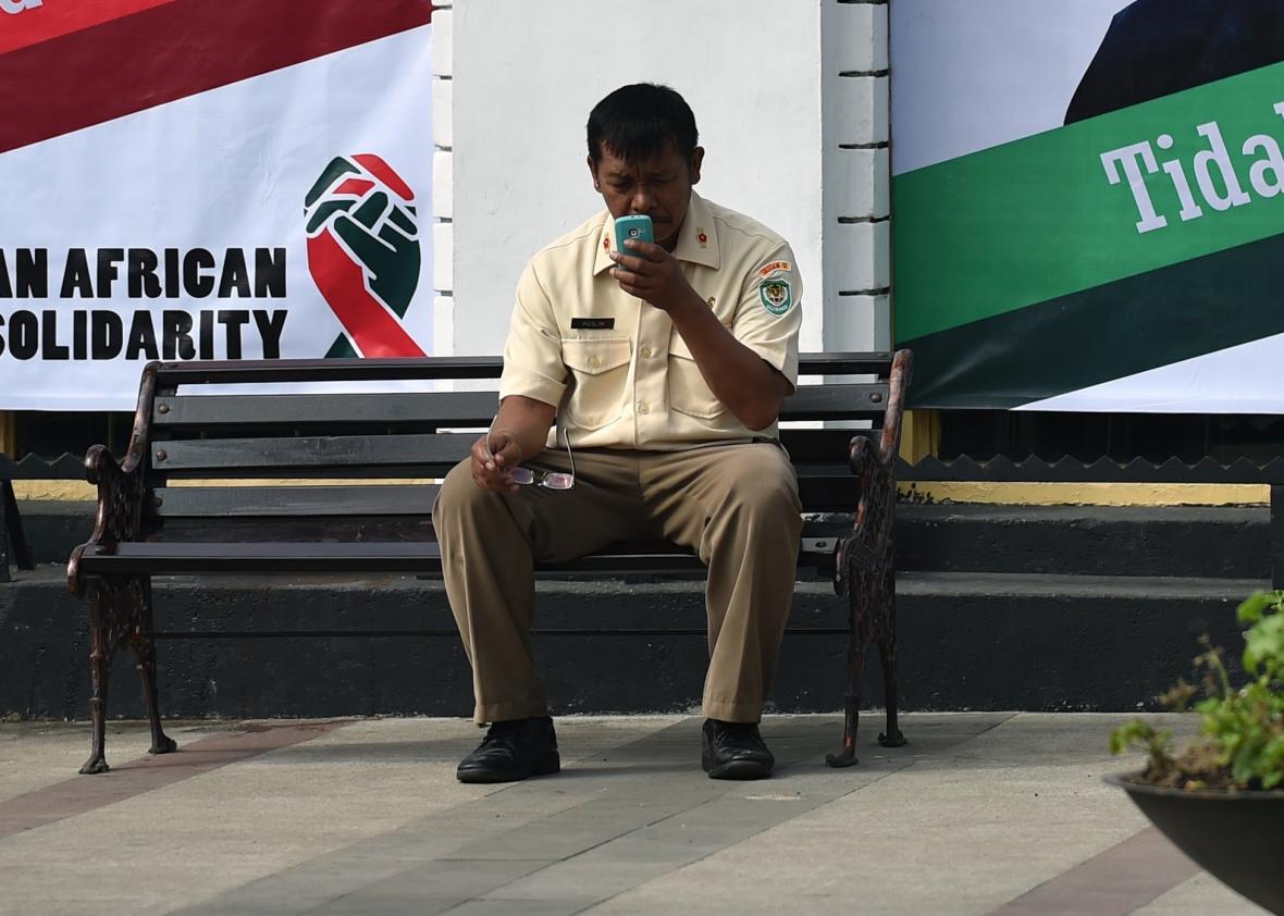 470757766-an-indonesian-man-looks-at-his-mobile-phone-while