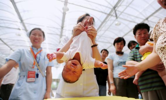 A doctor showing parents how to help their babies exercise.