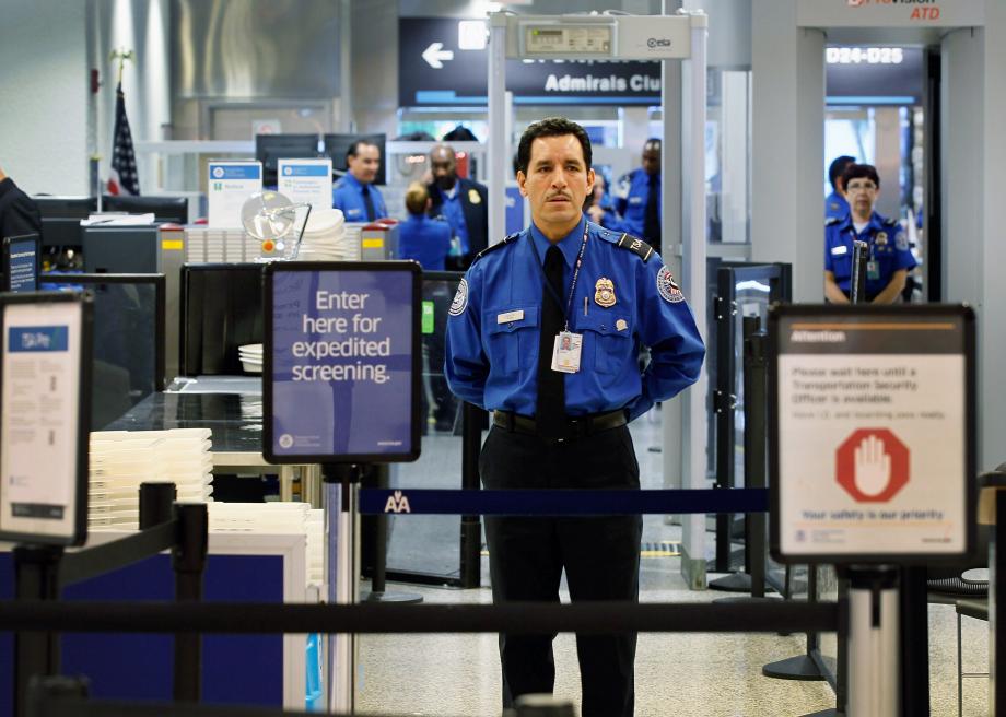 127987024-agent-waits-for-passengers-to-use-the-tsa-precheck-lane