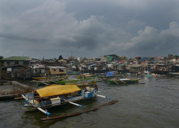 472839226-fishing-outrigger-boats-are-anchored-at-the-mouth-of-a