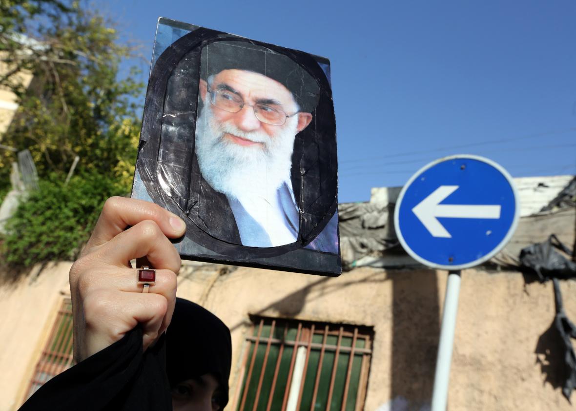 469589878-an-iranian-woman-holds-a-portrait-of-irans-supreme