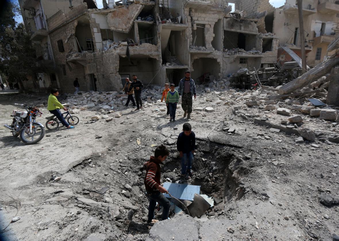 470327304-syrians-inspect-a-crater-on-the-ground-left-by-a 470327304-syrians-inspect-a-crater-on-the-ground-left-by-a
