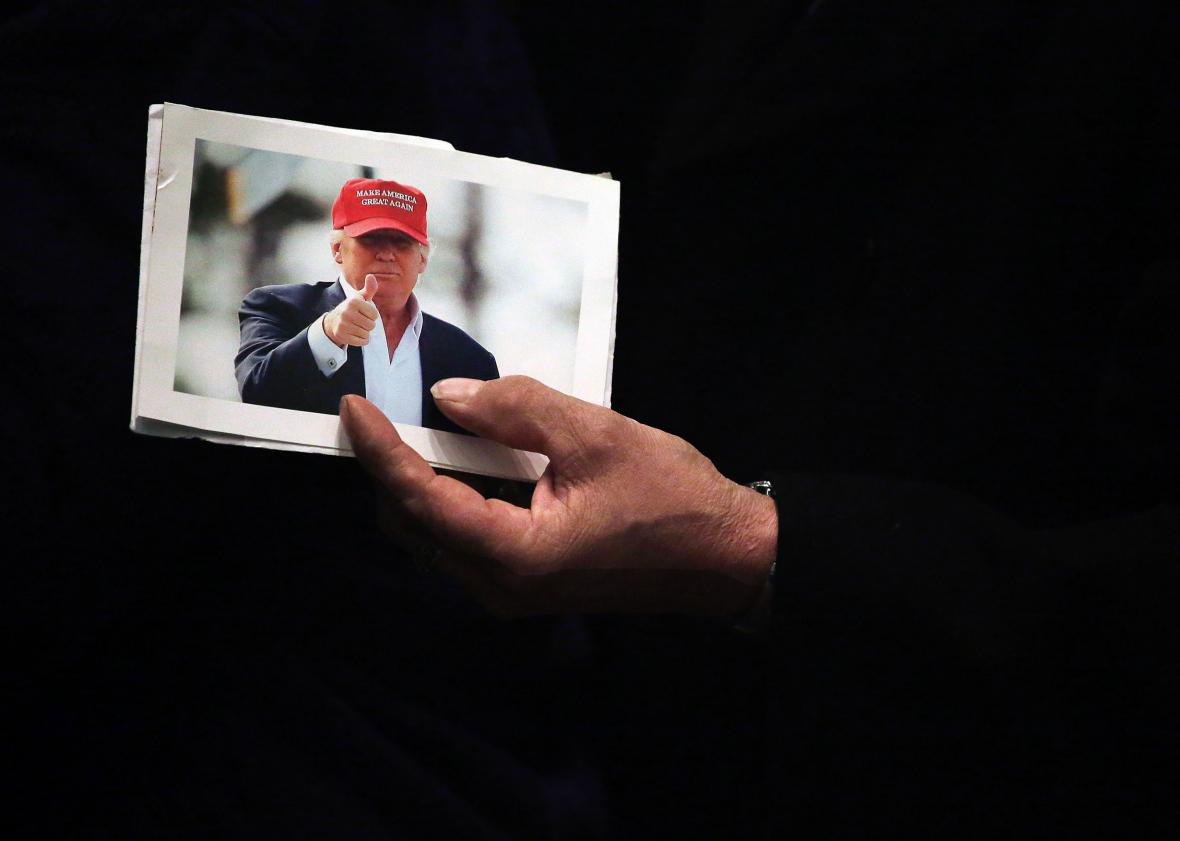 507926358-man-holds-a-picture-of-republican-presidential