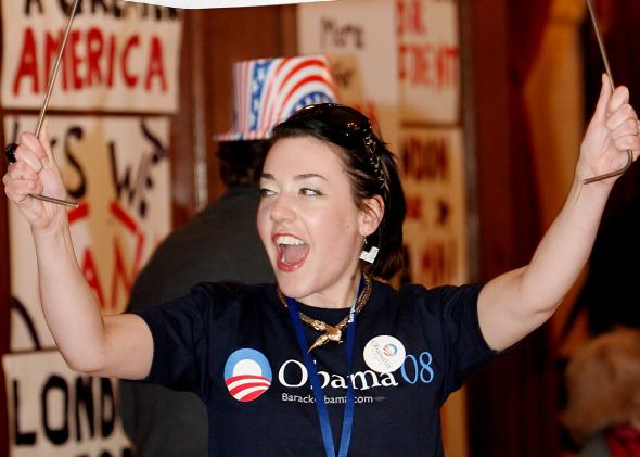 79529170-young-barack-obama-supporter-holds-up-a-banner-before