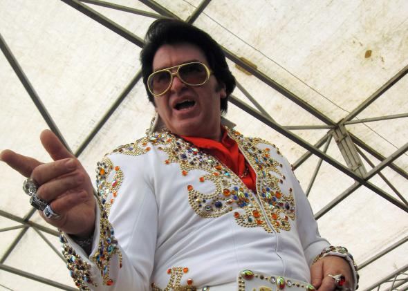 95684407-an-elvis-impersonator-strikes-a-pose-during-the-main