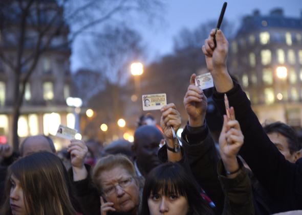 461127840-journalists-raise-their-press-cards-as-others-hold-up