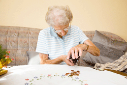 Older woman counts her change. Click to expand image.