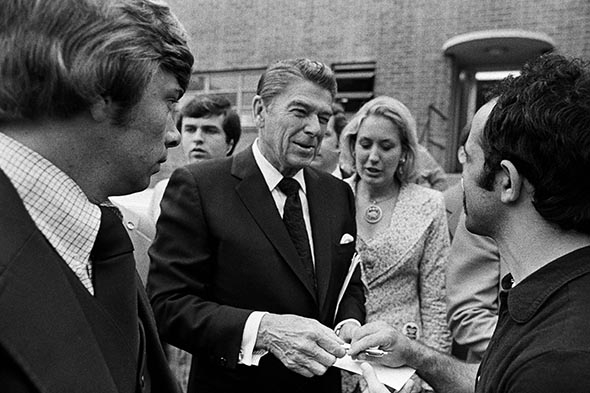 Presidential candidate Ronald Reagan signs autographs.