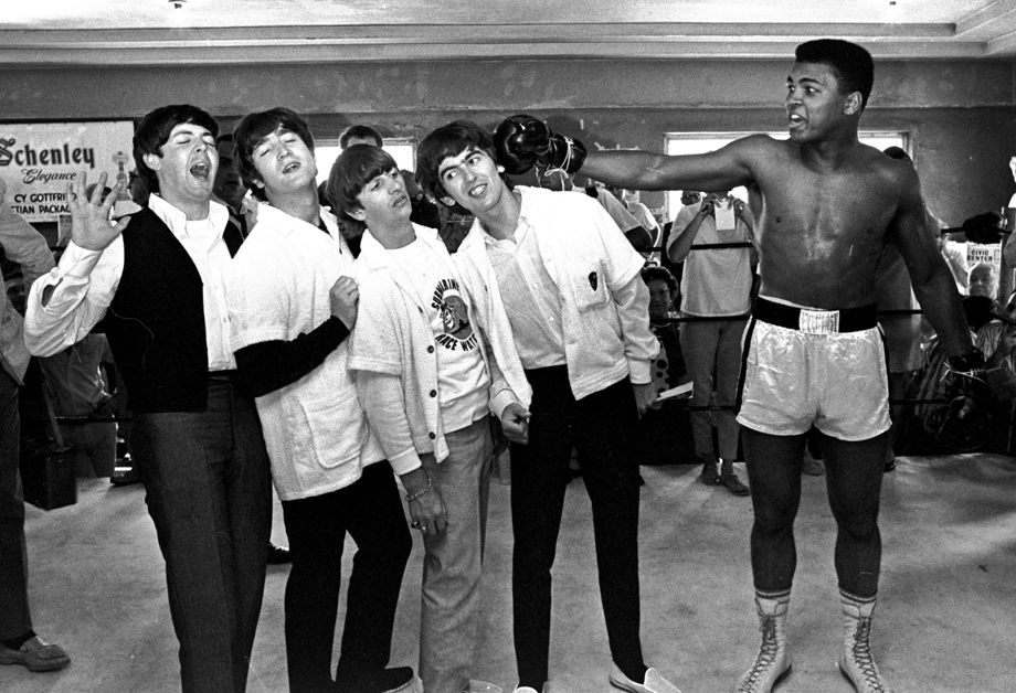 The Beatles, from left, Paul McCartney, John Lennon, Ringo Starr, and George Harrison, take a fake blow from Cassius Clay, who later changed his name to Muhammad Ali.