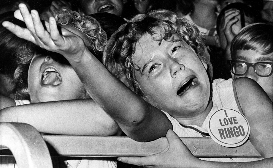 A tearful Beatles lover pleads unsuccessfully with a policeman to carry her fan button to Ringo.