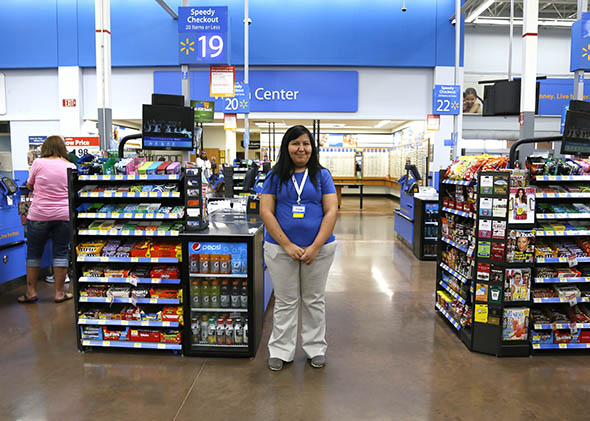 A cashier waits for customers at a Walmart Supercenter in Rogers, Arkansas June 6, 2013. 