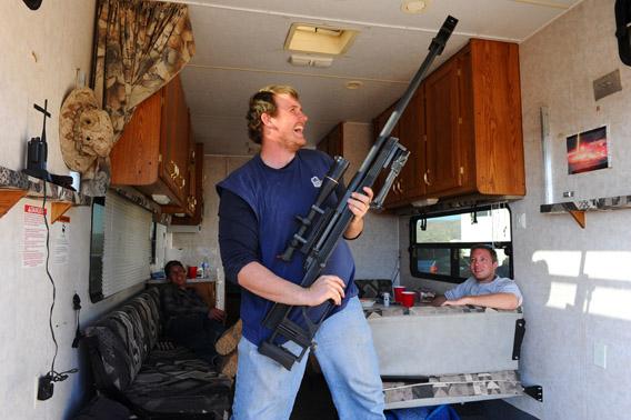 During a break in his trailer, Randall Bymoen&nbsp; shows off his gun at the Big Sandy Machine Gun Shoot in March. 