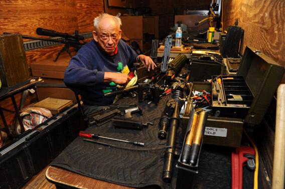 Machine-gun guru Dolf Goldsmith repairs a machine gun in his mobile shop at the Big Sandy Machine Gun Shoot in March. 