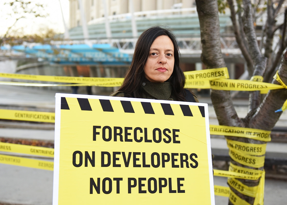 ASAP's Tamara Zahaykevich with evict landlords, not people, sign. ASAP, Artists Studio Affordability Project, capped a day of protest in front of the Brooklyn Museum with an tongue-in-cheek installation of indoor furniture and signs decrying the displacement incurred by gentrification.