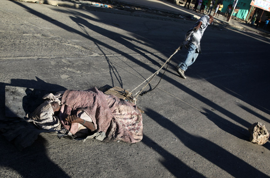 A man drags a dead cholera victim through the streets of Cap-Haitien on Nov. 19, 2010, after four days of riots between demonstrators and U.N. peacekeepers accused of bringing cholera to the country. Preparations for key upcoming elections pressed ahead despite violent clashes with U.N. troops blamed by Haitians for importing a cholera epidemic that has now claimed nearly 1,200 lives.