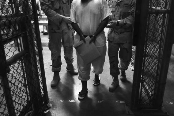 130411_FOR_slahi07 U.S. Navy guards escort a detainee after a "life skills" class held for prisoners at Camp 6 in the Guantanamo Bay detention center on March 30, 2010 in Guantanamo Bay, Cuba.