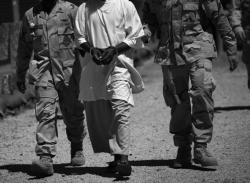 U.S. military guards move a detainee inside the American detention center for &quot;enemy combatants&quot; on September 16, 2010 in Guantanamo Bay, Cuba. 