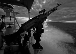 A side mounted SAW &quot;machine gun&quot; is at the ready at members of a US Coast Guard security detail, in a Viper fast boat, patrol the waters of Guantanamo Bay, Cuba 23 April 2007 at sunset.