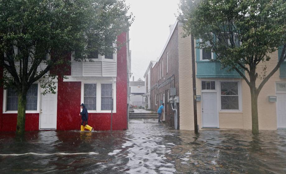 A man walks down a flooded street ahead of Hurricane Sandy on Monday in Atlantic City, New Jersey.