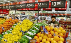 Sales associate Leo De La Cruz restocks fresh fruit during the Grand Opening of the new Walmart Neighborhood Market in Panorama City, California, a working class area about 13 miles (20km) northwest of Los Angeles, on September 28, 2012. 