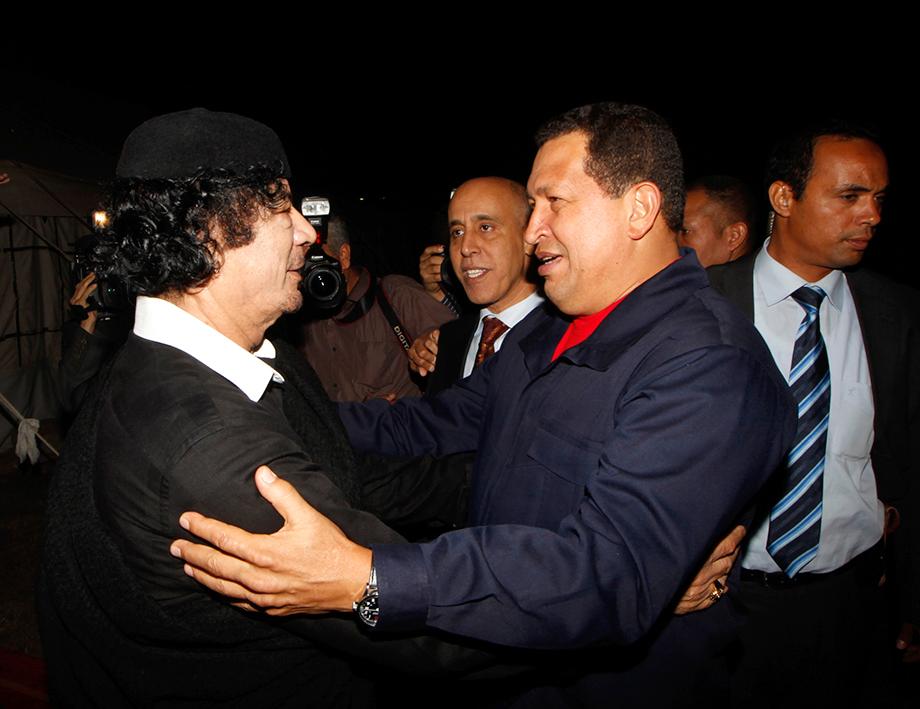 Libyan leader Moamer Kadhafi  (L)  welcomes Venezuelan President Hugo Chavez (R) upon his arrival in Tripoli on October 22, 2010. Chavez arrived in Libya for talks with the country's leader Moamer Kadhafi, on a regional tour that has also taken him to Iran and Syria. The firebrand president's programme has not been made public, but he arrived from Damascus and was to begin his visit by meeting Kadhafi, with whom he has had close ties for several years. AFP PHOTO MAHMUD TURKIA 
