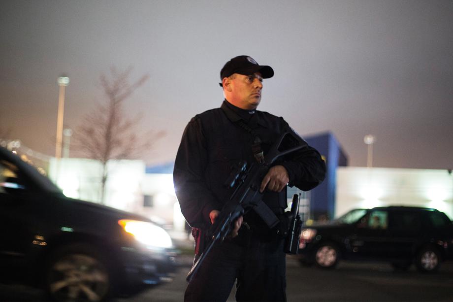 A law enforcement official stands with his rifle during a search for the two men suspected of setting off two explosions during the Boston Marathon in Watertown, Massachusetts, April 19, 2013. Massachusetts State Police warned people in the Boston suburb of Watertown not to open their doors and said they would conduct a door-to-door, street-by-street search due to what it called a fluid situation.