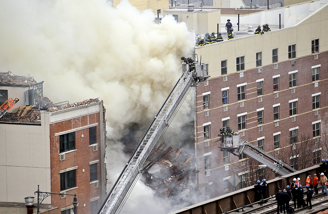 Firefighters from the Fire Department of New York respond to the five-alarm fire and building collapse.