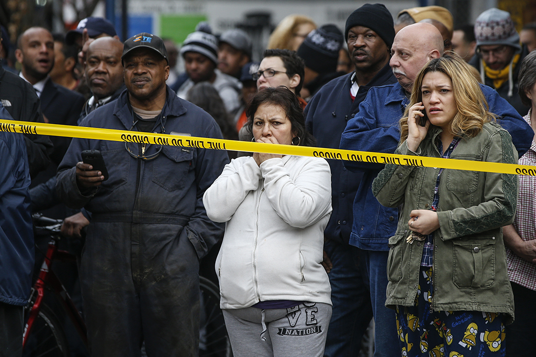 Residents watch as the Fire Department of New York searches for anyone trapped in the debris.