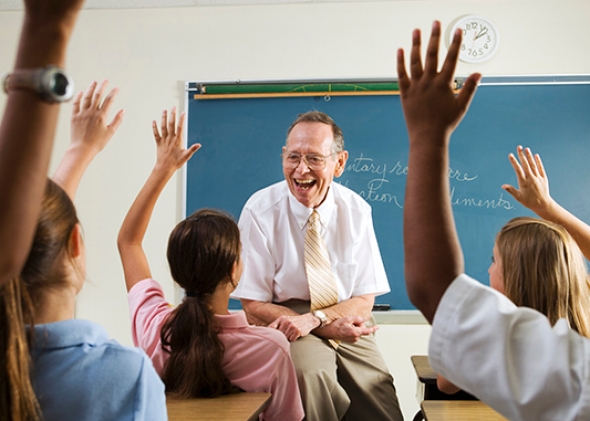 Students raise their hands in class.