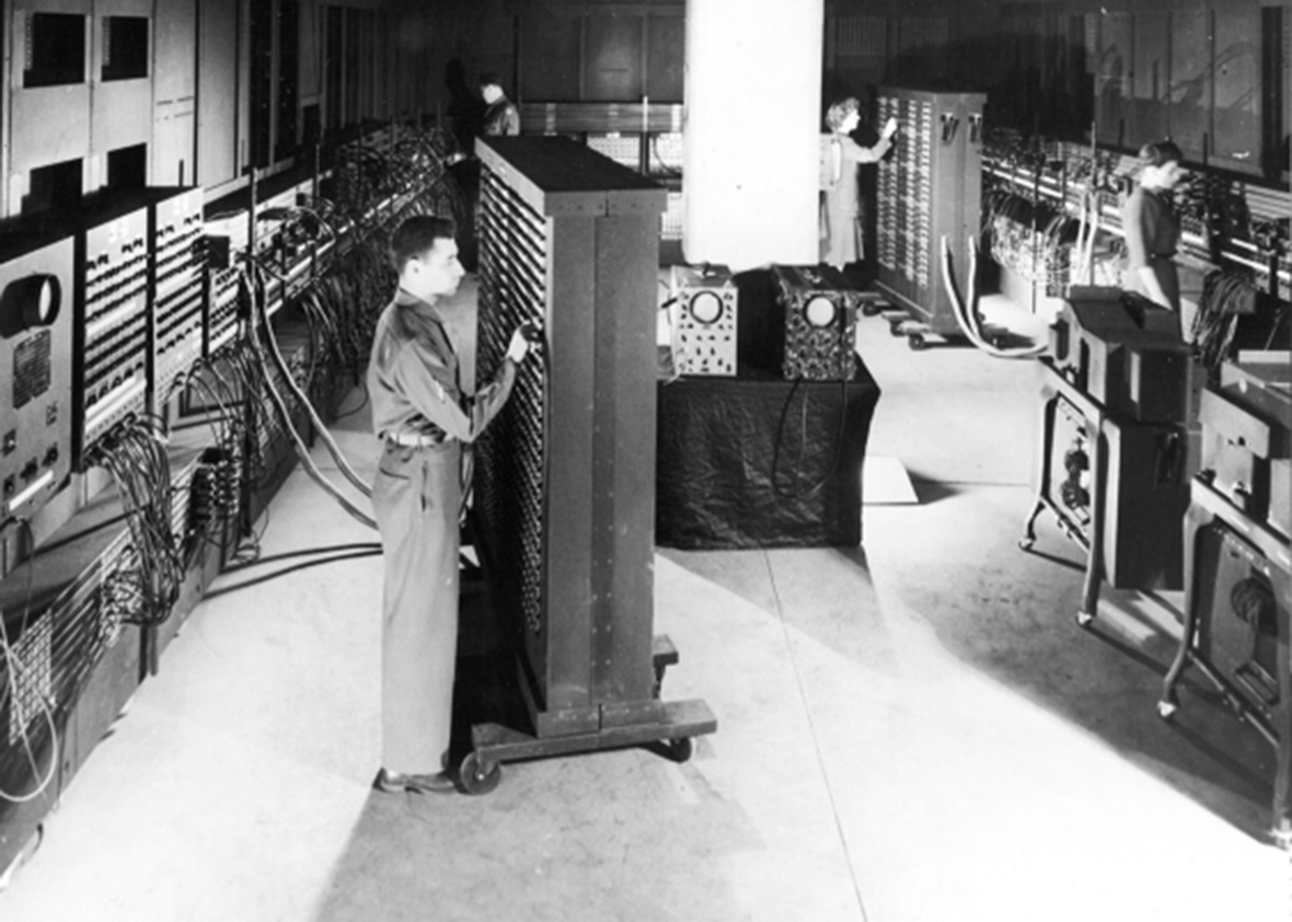 Cpl. Irwin Goldstein (foreground) sets the switches on one of the ENIAC's function tables at the Moore School of Electrical Engineering. 
