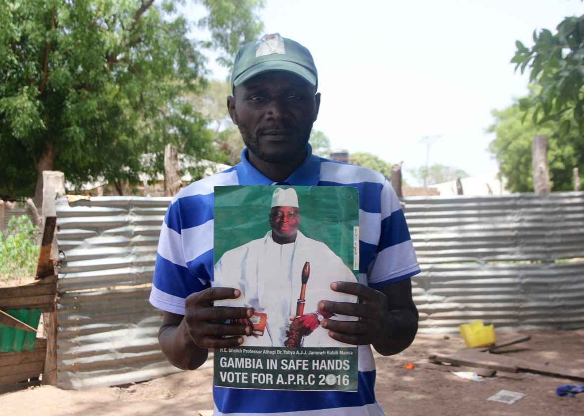 Kujabi poses with a sign from Jammeh&rsquo;s losing 2016 campaign he left me as a gift.