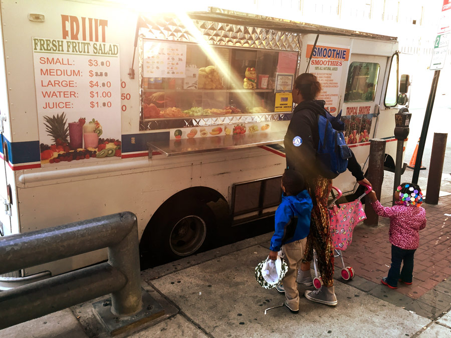 Hill stops at a fruit truck to get bananas for the kids. 