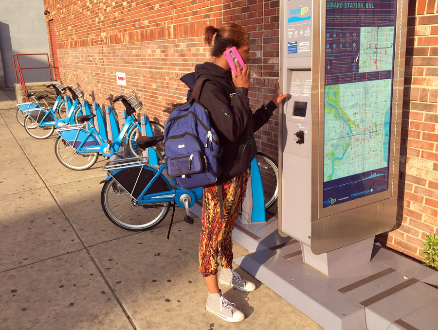After dropping off her kids, Hill busses to an Indego station to pick up a bike to head to work. She left her key card at home today, but a phone call to Indego gets her the code to undock a bike. 