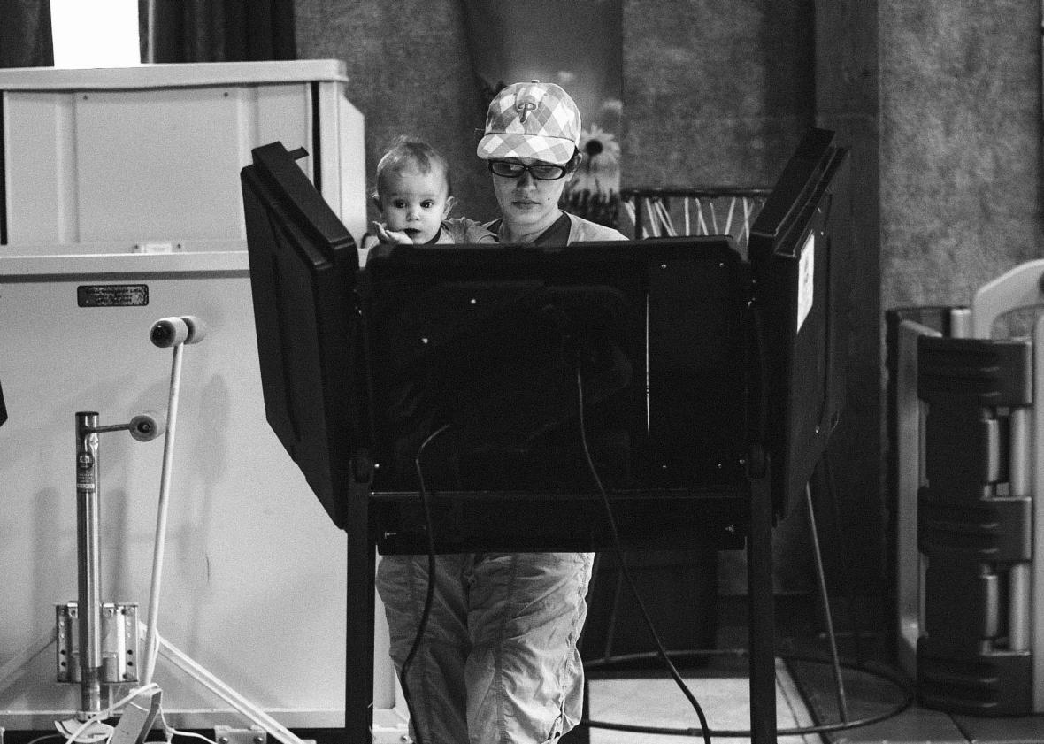 (C) Elisabeth Ford, 33, holds her son, Harrison, 8 months, while casting her vote at the Trucksville United Methodist Church polling station during the 2018 Pennsylvania Primary Election on May 15, 2018 in Trucksville, Pennsylvania.  Mark Makela/Getty Images