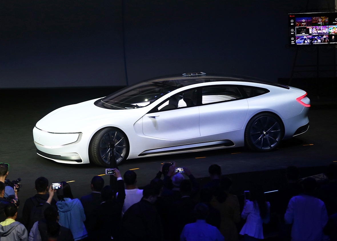 This photo taken on April 20, 2016 shows people taking photos of an internet electric battery driverless concept car 'LeSEE' during a launch event in Beijing. 