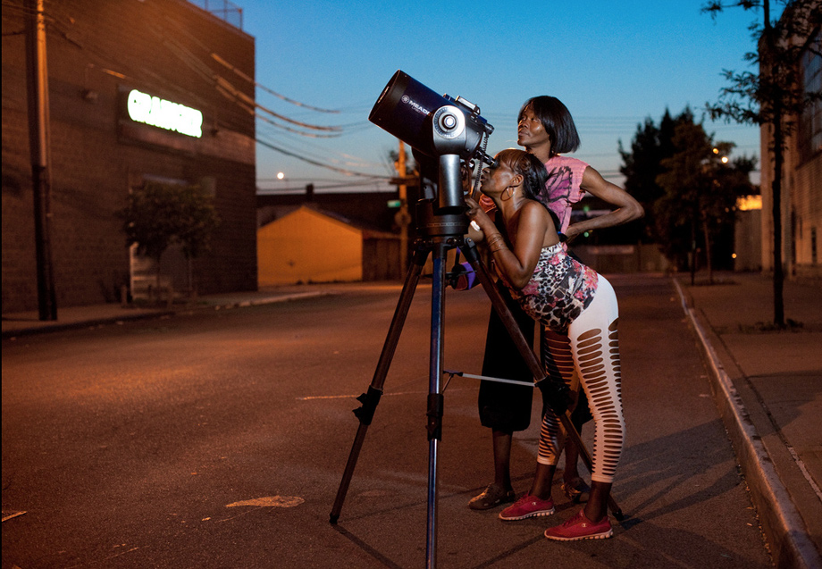 two women looking into a telescope