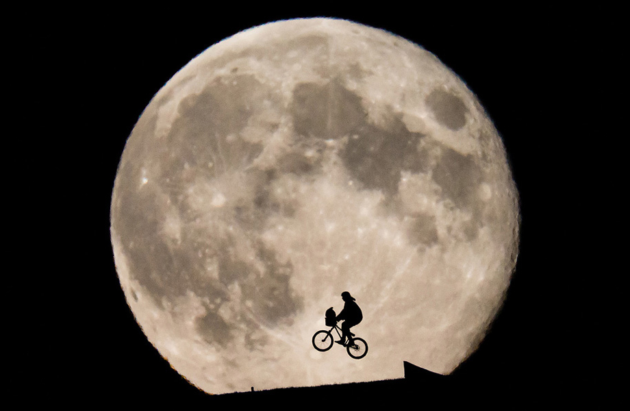 biker silhouetted in front of the Moon