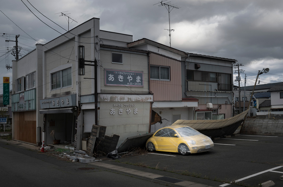 The town of Namie. All objects in the forbidden zone, including the car, cannot be taken back by their owners for reasons of contamination. The vehicles are abandoned in the parking awaiting for destruction.