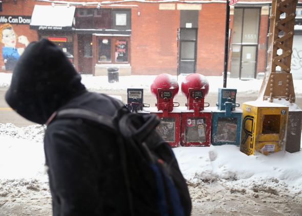 466944731-pedestrian-navigates-a-snow-covered-sidewalk-during-his_1